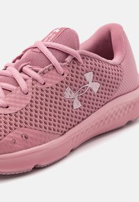 Scarpa sportiva rosa con una tomaia in mesh traspirante, dettagli testurizzati, lacci piatti e una suola in gomma rinforzata con un motivo di battistrada dettagliato.