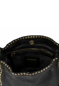 Interno di una borsa nera in pelle con borchie dorate lungo il bordo, dotata di una tasca con zip e una tasca piatta interna. Texture morbida e forma strutturata.