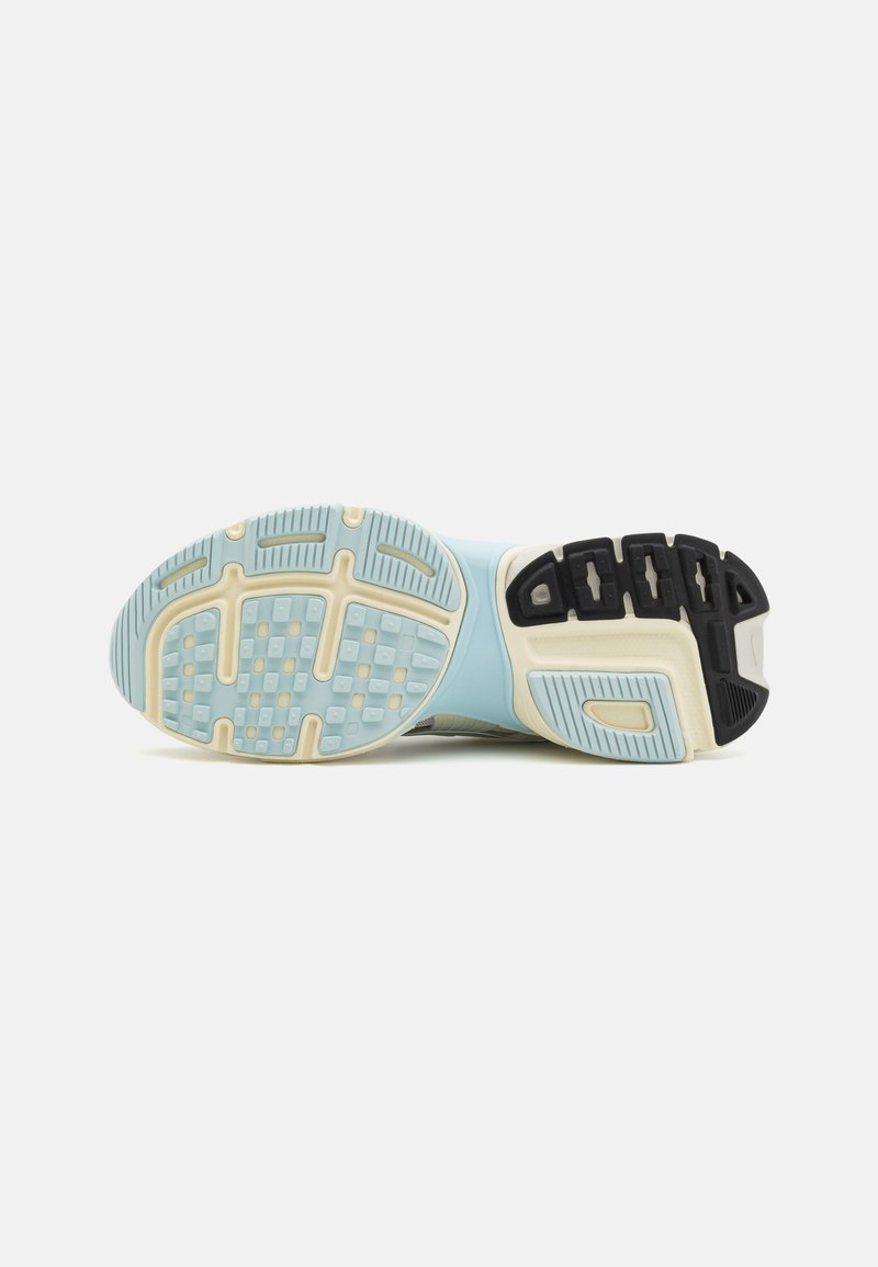 Zapatilla de correr con una suela de goma azul claro y blanca, que presenta agarraderas texturizadas y un acento negro. La entresuela tiene un acabado suave.