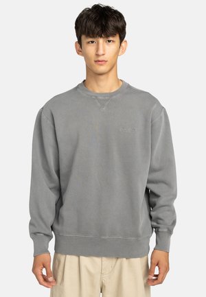 Gray sweatshirt made of cotton blend, featuring a crew neck, ribbed cuffs, and subtle branding on the chest. Simple, relaxed design.