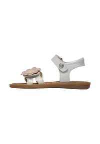 Sandalias blancas con un acabado texturizado, que presentan un gran acento de flor rosa y una correa ajustable, montadas sobre una suela de goma marrón.