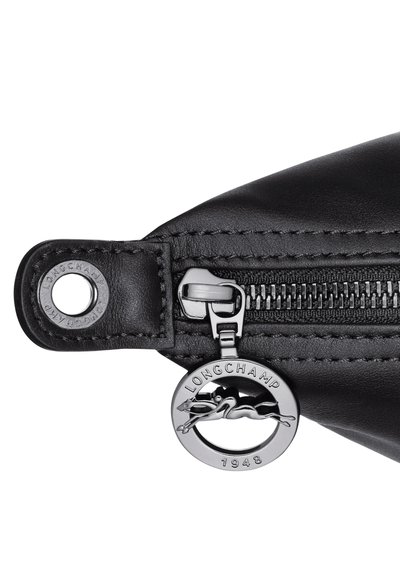 Black leather bag zipper with textured finish and metal charm featuring a leaping horse. Accented with a silver-tone tag and stitching details.