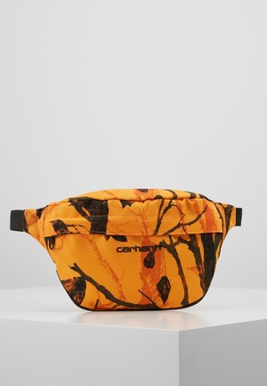 Compact Carhartt waist bag in bright orange with black branch-like pattern and front zipper pocket, displayed on white pedestal.