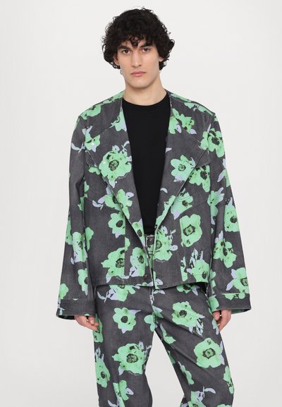 Blumenjacke und -hose aus Jeans, mit einem dunkelgrauen Hintergrund, großen grünen Blumen und blauen Akzenten.