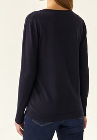 Marineblauer Strickpullover mit langen Ärmeln, rundem Halsausschnitt und gerippten Bündchen und Saum. Weiches Material und schlichtes Design. Rückansicht gezeigt.