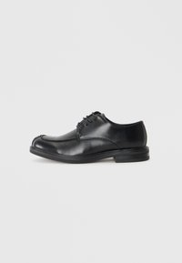 Chaussures en cuir noir à lacets avec un bout arrondi, texture lisse et un petit talon. Présente des détails de couture le long de l'empeigne et des côtés.