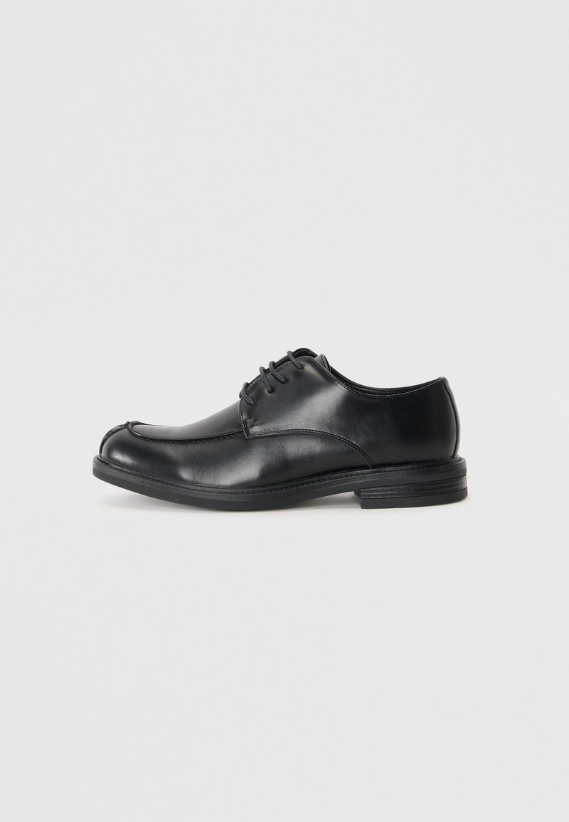 Chaussures en cuir noir à lacets avec un bout arrondi, texture lisse et un petit talon. Présente des détails de couture le long de l'empeigne et des côtés.
