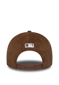 Bruine corduroy baseballpet met verstelbare kunststof band en wit geborduurd logo op de achterkant.