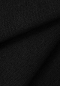 Schwarzer Stoff mit feiner diagonaler Rippstruktur, gefaltet, um überlappende Schichten und subtile Schattierungsvariationen zu zeigen.