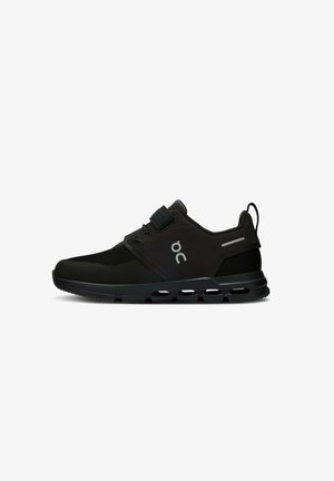 Chaussure de sport noire avec une tige en maille, semelle en caoutchouc et semelle intermédiaire rembourrée. Équipée d'une sangle Velcro et d'un logo discret.