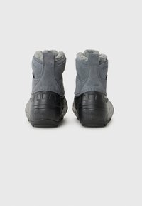 Bottes d'hiver grises avec une semelle noire texturée et un doublure en fourrure, arborant le logo Columbia sur le côté, montrées de l'arrière.