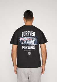 Schwarzes Baumwoll-T-Shirt mit dem Schriftzug "FOREVER FORWARD" und einer Grafik eines Fußballs, mit blauen, roten und weißen Akzenten. USMNT-Logo am unteren Rand.