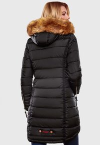 Black padded coat with a fur-lined hood. Features side zippers and logo accents, creating a textured, quilted appearance.