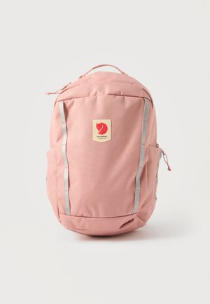 Mochila Fjällräven rosa con dos tiras reflectantes verticales, asa superior, bolsillos laterales y parche de logo en el centro frontal.
