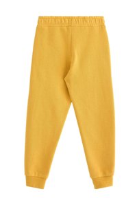 Gule bomulds-sweatpants med elastisk taljebånd, tilspidsede ben og ribstrikkede manchetter. Glat tekstur og enkelt design uden mønstre eller detaljer.
