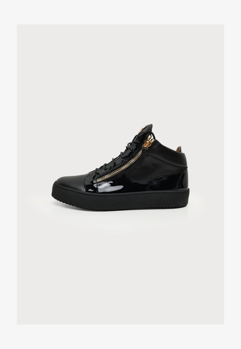 Μαύρο sneaker ψηλού τύπου με γυαλιστερό φινίρισμα, μαύρα κορδόνια, χοντρή σόλα και χρυσό πλαϊνό φερμουάρ σε απλό φωτεινό φόντο.