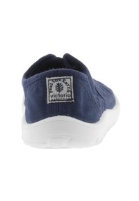 Scarpa slip-on in tela navy con suola bianca; presenta una parte superiore testurizzata e un'etichetta con logo ad albero sul tallone.