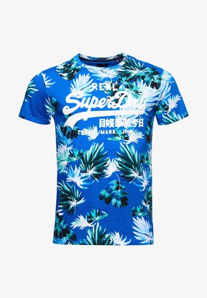 Blauw T-shirt met korte mouwen, met groene en witte tropische bladerenpatronen en witte "Real SuperDry" logo tekst over de borst.