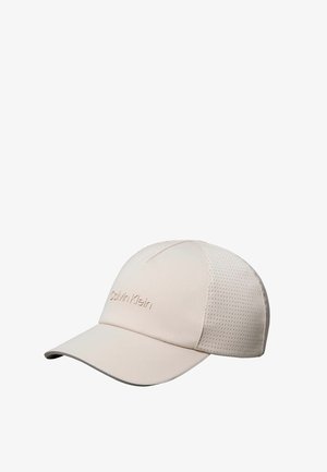 Lichtbeige Calvin Klein baseballpet met geperforeerde zijkanten en gebogen klep tegen witte achtergrond.