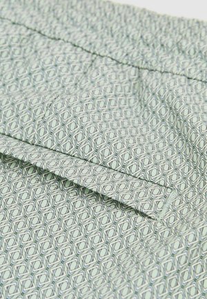 Lys grøn stof med et geometrisk mønster, der har overlappende diamanter omridset af mørkegrøn. Glat tekstur med synlige folder.