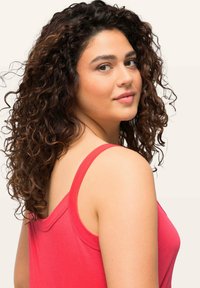 Red tank top featuring thin straps and a relaxed fit. The fabric appears soft with a smooth texture, suitable for casual wear.