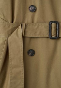 Khaki trencz z paskiem w talii, z zapięciem na dwa guziki i gładką teksturą materiału. Zawiera duże czarne guziki oraz detale w szwach.