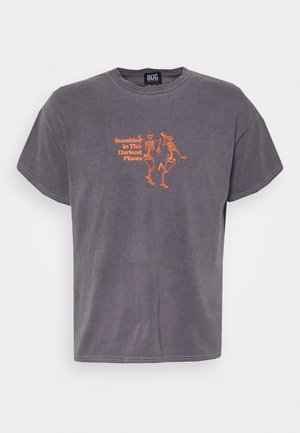 Kohlegraues T-Shirt mit orangefarbenem Text "Sunshine in The Darkest Places" und einer Grafik tanzender Skelette auf der Brust.