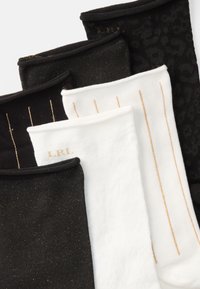 Pieci pāri potīšu zeķu: divi melni ar zelta flekiem, viens melns ar leoparda rakstu, divi balti ar zelta svītrām un viens balts ar "LRL" detaļu.