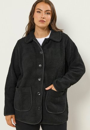 Zwarte fleecejack met een kraag, sluiting met knopen aan de voorkant, twee voorzakken en contrasterende afwerking langs de randen. Zacht oppervlak overal.