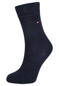 Calcetín de algodón azul marino con puño acanalado, textura suave y pequeño detalle del logo en rojo, blanco y azul cerca de la parte superior. Diseño de longitud hasta el tobillo.