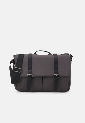 Borsa a tracolla grigia con fasce in pelle nera, fibbie argentate e una tracolla nera regolabile su uno sfondo bianco.