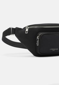Marsupio nero dal design elegante, realizzato in materiale liscio. Presenta cerniere argento e una tasca frontale con un dettaglio del logo.