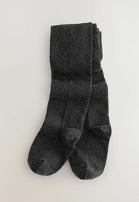 Mørkegrå sokker med en blød tekstur, der har et diskret hjerte mønster og et klassisk design. De er rullet sammen pænt.