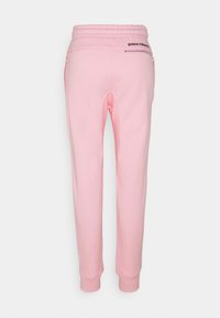 Rosa sweatpants med dragsko i midjan, med en ficka bak med dragkedja och ribbade muddar. Tillverkade av mjukt och hållbart tyg.