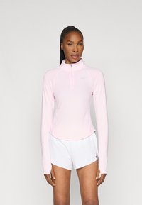 Bluză lungă cu mânecă din materiale fine, de culoare roz pal, cu guler cu fermoar și mâneci raglan. Design simplu cu un mic logo Nike pe piept.