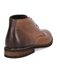 Brązowe skórzane botki za kostkę z detalami w stylu brogue, z kontrastującym ciemniejszym skórzanym obcasem i solidną, teksturowaną podeszwą.