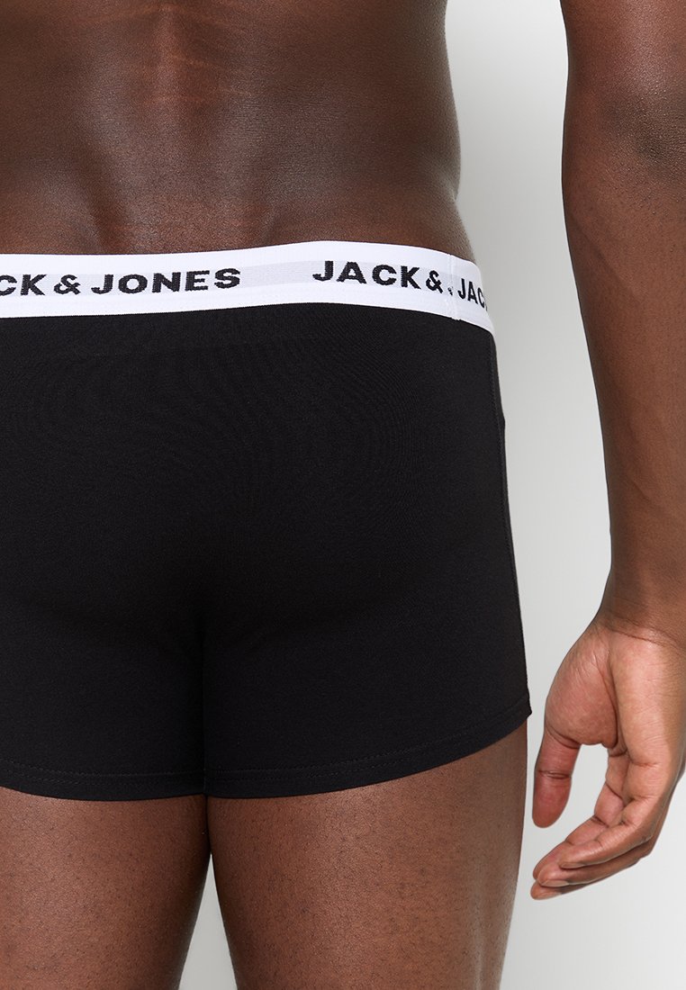 Mann in schwarzen Boxershorts mit weißem Bund, auf dem "JACK & JONES" steht, von der hinteren Taille bis zur Mitte des Oberschenkels dargestellt.