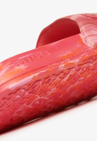 Zapato de goma rosa sin cordones con suela texturizada y marca Superdry, que presenta una parte superior suave y bordes redondeados para un ajuste cómodo.