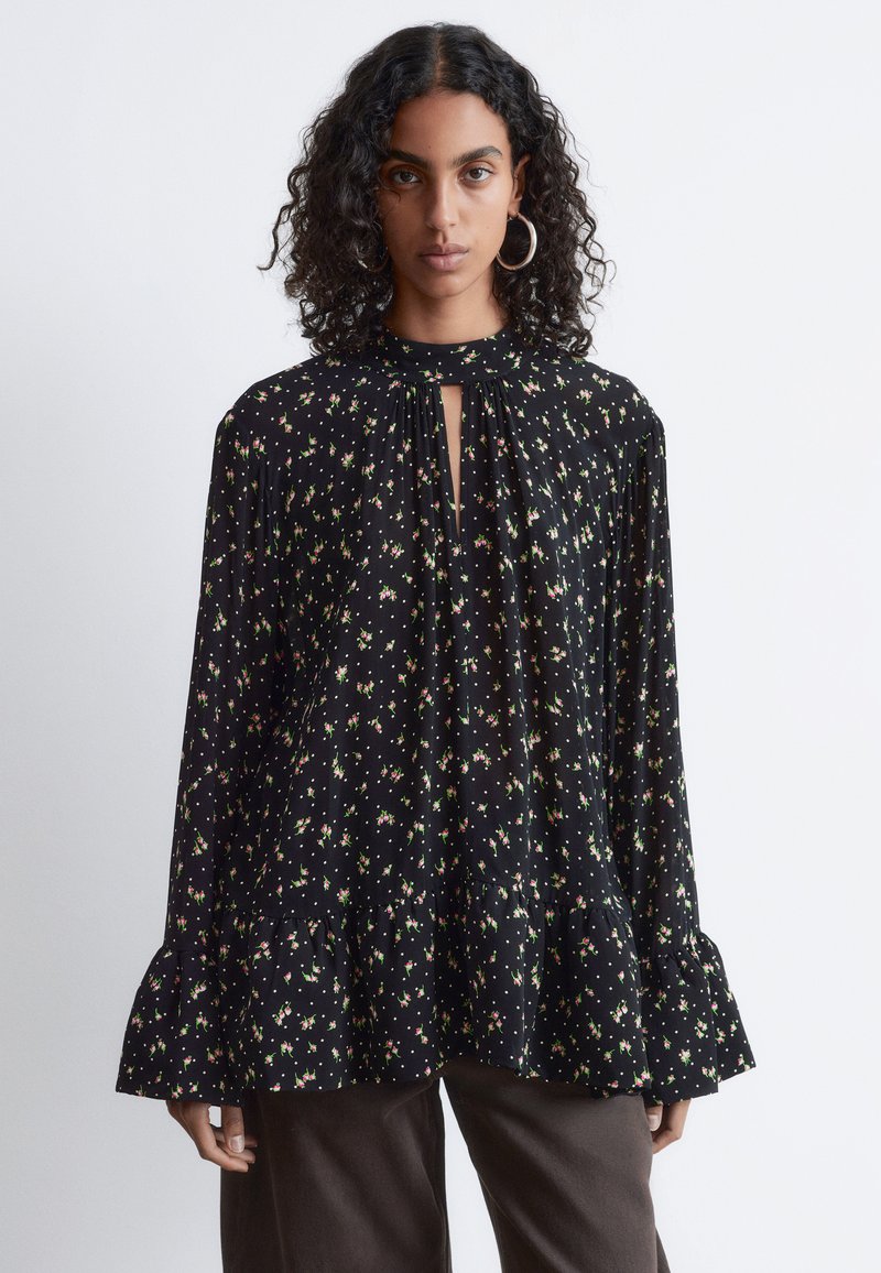 Schwarz blouse mit floralem Druck in Pink und Grün, mit schlüsselloch-Ausschnitt, plissiertem Design und ausgestellten Ärmeln. Hergestellt aus leichtem Stoff.