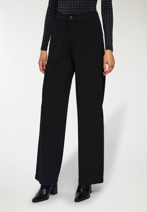 Pantaloni neri a gamba larga realizzati in un tessuto morbido e strutturato, con una cintura liscia, chiusura frontale con bottone e tasche laterali.
