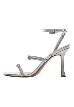 Silberne High-Heel-Sandale mit drei dünnen Riemchen, eines um den Knöchel, vor weißem Hintergrund.