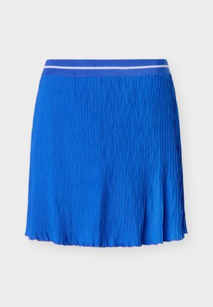 Falda azul plisada con una cintura elástica a rayas blancas sobre un fondo gris claro liso.