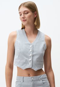 Gestreifte, verkürzte Weste in Blau und Weiß, mit V-Ausschnitt, f�ünf Knopfverschlüssen und zwei Taschen, aus leichtem Material hergestellt.