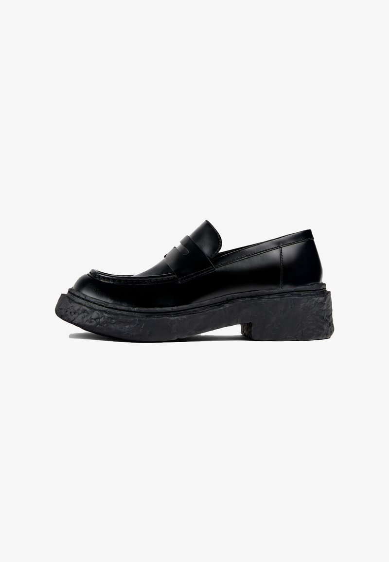 Svarta loafers i slät läder, med rund tå och en tjock, texturerad svart platåsål. Snygga linjer med minimala accenter.