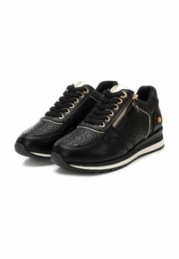 Zapatillas negras con un diseño perforado, acentos en dorado metálico, cordones y un zipper lateral. Presenta una suela texturizada y un collar acolchado.