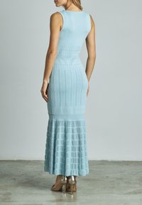 Helles blaues Strickkleid mit tailliertem Oberteil und ausgestelltem, gerafftem Saum. Verfügt über strukturierte Muster und eine glatte Oberfläche.