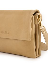 Braune Leder-Clutch mit Überschlag, goldenen Beschlägen und abnehmbarem Schultergurt. Dezente Textur und Markenlogo auf der Vorderseite.
