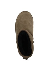Stivale alla caviglia in suede marrone con punta arrotondata e morbida fodera nera. Presenta una linguetta sul retro e una superficie liscia e strutturata.