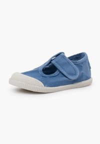 Scarpa in tela blu con punta arrotondata, suola in gomma bianca e cinturino regolabile sul piede. Parte superiore testurizzata con una fodera liscia.