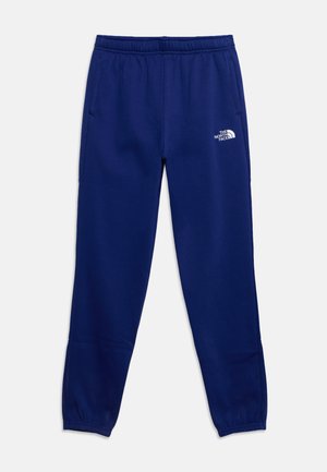 Pantalon de survêtement bleu marine avec ceinture élastique et poignets aux chevilles, poches latérales, et un logo blanc The North Face sur la cuisse gauche.